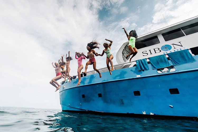 Women jumping into the ocean